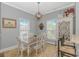 A dining room features a wood table with white chairs, a chandelier and light gray walls at 212 Greenwich Dr., Conway, SC 29526