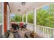 Covered front porch offering outdoor seating with decorative pillows, dark wicker furniture, and lush greenery at 212 Greenwich Dr., Conway, SC 29526