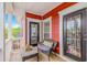Relaxing porch with a cushioned chair, a small table, and a view of the neighborhood trees and clear sky at 212 Greenwich Dr., Conway, SC 29526