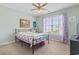 Bright bedroom featuring neutral walls, a ceiling fan, and a large window with views of the outdoors at 212 Sweetbay Magnolia St., Loris, SC 29569
