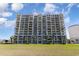 Exterior of a luxury condo building featuring multiple balconies and manicured lawn area at 2151 Bridge Ct. # 1-305, North Myrtle Beach, SC 29582