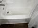 Bright bathtub with chrome faucet and shower head and curtain with dark brown floor at 217 N Myrtle St. # 1, Myrtle Beach, SC 29577