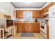 Efficient kitchen with wood cabinets, white appliances and adjacent breakfast nook at 2191 Liberty Circle, Little River, SC 29566