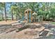 Charming community playground with wooden play structures, slides, and picnic tables amidst trees at 2191 Liberty Circle, Little River, SC 29566
