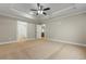 Large bedroom with a ceiling fan, tray ceiling, neutral paint, carpet, and access to bath at 2260 Pearl Rd., Galivants Ferry, SC 29544