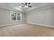 Bedroom featuring a ceiling fan, tray ceiling, neutral paint, carpet, and large window at 2260 Pearl Rd., Galivants Ferry, SC 29544