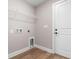 Laundry room with wood-look floors, shelving, washer-dryer hookups, and white door at 2260 Pearl Rd., Galivants Ferry, SC 29544