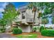 Unique elevated home with a rooftop deck surrounded by lush greenery and a tranquil waterside view at 24 Frigate Ct., Pawleys Island, SC 29585