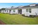 Spacious backyard with green lawn, white siding, and screened-in porches for outdoor living at 253 Bent Green Ct. # 70D, Murrells Inlet, SC 29576