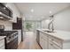 Bright kitchen features white cabinets, stainless steel appliances, and island with quartz countertop at 253 Bent Green Ct. # 70D, Murrells Inlet, SC 29576