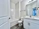 Bathroom featuring gray laminate flooring, a tub-shower combo, single vanity, and white walls at 2593 Main St., Loris, SC 29569
