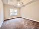 Bedroom with neutral carpet, tray ceiling with fan and a bright window at 2593 Main St., Loris, SC 29569