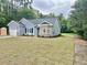 A well manicured lawn wraps around the property, featuring a blue vinyl sided home, and an attached garage at 2593 Main St., Loris, SC 29569