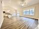 Open living room with light wood flooring, large windows and an open kitchen area at 2593 Main St., Loris, SC 29569