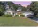 Charming single story home with blue door, manicured landscaping, and boat parked in front of the garage at 2604 South Bay St., Georgetown, SC 29440