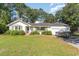 Charming single story home with blue door, manicured landscaping, and boat parked in front of the garage at 2604 South Bay St., Georgetown, SC 29440