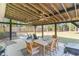 Covered patio featuring string lights, ceiling fans, outdoor seating, and a dining table with a grill at 2604 South Bay St., Georgetown, SC 29440