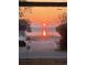 Breathtaking water view through a window, capturing a vibrant sunrise that reflects on the serene water at 2604 South Bay St., Georgetown, SC 29440