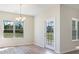Bright dining area with chandelier, windows, and a glass paneled door to the outside at 268 Stillbrook Dr., Longs, SC 29568