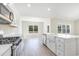 Modern kitchen with stainless steel appliances, an island with a farmhouse sink, and ample cabinet space at 268 Stillbrook Dr., Longs, SC 29568