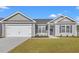 Charming single-story home featuring a two-car garage, and manicured lawn with inviting curb appeal at 271 Stillbrook Dr., Longs, SC 29568