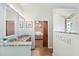 Bright bathroom featuring double sinks with marble countertops, a walk-in shower, and access to the main bedroom at 284 Nature Trail, Little River, SC 29566