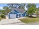 Charming blue single-Gathering home featuring a garage and inviting pergola-covered patio, surrounded by lush landscaping at 284 Nature Trail, Little River, SC 29566