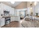 Modern kitchen featuring stainless steel appliances, white cabinets, granite countertops, and a breakfast bar area at 284 Nature Trail, Little River, SC 29566