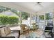 Cozy screened-in porch with wicker furniture, offering a relaxing outdoor space with views of the backyard at 284 Nature Trail, Little River, SC 29566