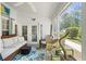 Comfortable screened porch with wicker seating and a colorful rug, perfect for enjoying the outdoors at 284 Nature Trail, Little River, SC 29566