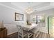 Bright dining room featuring a white table, bench seating, pendant lighting, and a window overlooking the front yard at 3136 Robins Nest Way, Myrtle Beach, SC 29579