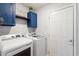 Laundry room featuring white cabinets, blue cabinets and a front loading washer and dryer at 3136 Robins Nest Way, Myrtle Beach, SC 29579