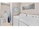Efficient laundry room with washer, dryer, and added boat shelf for storage, plus fun laundry art at 3401 N Ocean Blvd. # 309, North Myrtle Beach, SC 29582