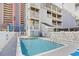 Outdoor pool area with shallow end, surrounded by a white fence and adjacent building at 3401 N Ocean Blvd. # 309, North Myrtle Beach, SC 29582