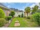 Landscaped backyard with stone pathway and mature trees and plants, offering a serene outdoor space at 372 Waterfall Circle, Little River, SC 29566