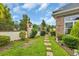 Serene backyard garden featuring a stone pathway and bordered by a wrought iron fence and lush landscaping at 372 Waterfall Circle, Little River, SC 29566