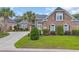Charming brick home with manicured lawn, mature landscaping, and elegant architectural details at 372 Waterfall Circle, Little River, SC 29566