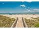 Picturesque boardwalk leading to a pristine beach with clear blue skies and ocean views at 400 Melrose Pl. # 14E, Myrtle Beach, SC 29572