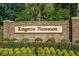 Beautifully landscaped entrance to Kingston Plantation with a brick sign amidst colorful flowers and lush greenery at 400 Melrose Pl. # 14E, Myrtle Beach, SC 29572