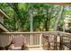 Wood deck with chairs and small tables and a view of the treed lawn at 400 Melrose Pl. # 14E, Myrtle Beach, SC 29572