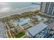 Expansive pool area with lounge chairs, palm trees, and a view of the ocean, perfect for relaxation at 400 Melrose Pl. # 14E, Myrtle Beach, SC 29572