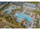 Aerial view of a modern recreation area with pools, lounge areas, and palm trees, perfect for outdoor fun at 400 Melrose Pl. # 14E, Myrtle Beach, SC 29572