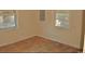 Small bedroom with two windows and worn hardwood flooring at 414 E Wine St., Mullins, SC 29574
