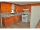 Compact kitchen with wood cabinets, a white gas range, and tile backsplash at 414 E Wine St., Mullins, SC 29574