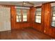 Sunlit room with wood paneling, hard floors, multiple windows, and a white door at 414 E Wine St., Mullins, SC 29574