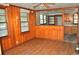 Living room with wood paneled walls, hardwood floors, a ceiling fan, and natural light at 414 E Wine St., Mullins, SC 29574