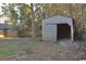 Rustic storage shed in the backyard, surrounded by trees and foliage at 414 E Wine St., Mullins, SC 29574
