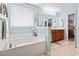 Bright bathroom featuring a soaking tub, double vanity, and ample natural light from a window at 424 Enderby Way, Little River, SC 29566