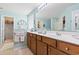 Well-lit bathroom with double sink vanity, large mirror, and separate toilet and shower area at 424 Enderby Way, Little River, SC 29566
