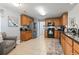 Eat-in kitchen with wooden cabinets, tile floors, stainless steel refrigerator and black appliances at 424 Enderby Way, Little River, SC 29566
